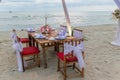 Romantic dinning table on the beach . Table setting at a luxury wedding and Beautiful flowers on the table. Royalty Free Stock Photo