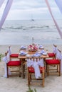 Romantic dinning table on the beach . Table setting at a luxury wedding and Beautiful flowers on the table. Royalty Free Stock Photo