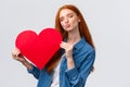 Romantic dreamy cute redhead teenager dreaming about giving boyfriend big red heart card to show her affection and love