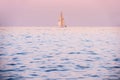 A romantic dreamy seascape with a sail boat on the horizon