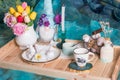 Romantic Easter table setting with candles, a white knitted plate, a cup with a drink.