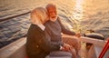 Romantic evening on the boat. Portrait of happy senior couple holding hands, hugging and kissing Royalty Free Stock Photo