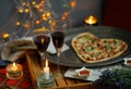 Romantic evening with champagne, candles and heart shaped Pizza. Love. Celebrate holidays Royalty Free Stock Photo