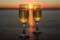 Romantic evening, sunset, two wineglasses, sun path on the water between two wineglasses with wine Royalty Free Stock Photo