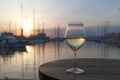 Romantic evening sunset with misty glass of white wine on background of sea harbor. Royalty Free Stock Photo