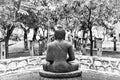Black and white stone statue of Buddha sitting and meditating in the tropical spa garden Royalty Free Stock Photo