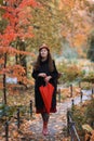 Romantic fall outdoor retro vintage portrait of woman in hat and coat with red umbrella and boots Royalty Free Stock Photo