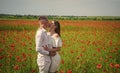 Romantic feelings. happy relations. girl and guy in field. bride and groom. romantic couple with red poppy flowers Royalty Free Stock Photo