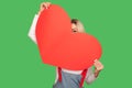 Romantic feelings. Portrait of playful positive woman shy of confessing love hiding and peeking out of huge red heart