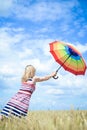 Romantic female flying with umbrella in the wheat