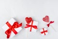Romantic festive background - white gift boxes with red bow, sweet lollipops hearts on white wood board as decorative border. Royalty Free Stock Photo