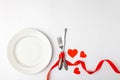 Romantic festive table setting on white background. Valentines day card template. Red ribbon, plate, silverware, vintage