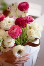 Romantic floral composition with a pink Ranunculus flowers closeup. Beautiful bouquet of flowers in white basket Royalty Free Stock Photo