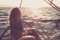 Romantic and free alternative lifestyle woman sit down on the yacht enjoy the sunset in summer travel - ocean and sunlight in Royalty Free Stock Photo