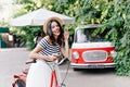 Romantic girl in long skirt posing with pleasure on the street with bicycle. Outdoor portrait of go Royalty Free Stock Photo