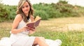 Romantic girl reading a book sitting outdoors Royalty Free Stock Photo