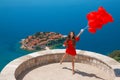 Romantic girl in red dress over Sveti Stefan island in Budva, Mo Royalty Free Stock Photo