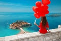 Romantic girl in red dress over Sveti Stefan island in Budva, Mo Royalty Free Stock Photo