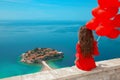 Romantic girl in red dress over Sveti Stefan island in Budva, Mo Royalty Free Stock Photo