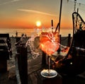 romantic  glass of coctail  ice water splash and sun beam flares on wooden table top sunset at sea in beach restaurant view in Royalty Free Stock Photo
