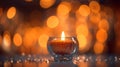 Romantic golden candle on table with blurred sparkling bokeh background.