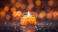 Romantic golden candle on table with blurred sparkling bokeh background.