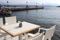 Romantic Greek restaurant with white chairs and tables near sea, tourism travel Royalty Free Stock Photo