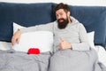 Romantic greeting. morning surprise from his valentine. happy valentines day. bearded man hold decoration heart in bed Royalty Free Stock Photo