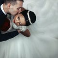 Romantic groom kissing brunette bride on the neck, shot from above closeup