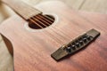 Romantic guitar music...Close up photo of the brown acoustic guitar lying on the wooden floor.