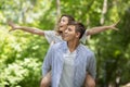 Romantic guy giving his girlfriend piggyback ride at beautiful summer park Royalty Free Stock Photo