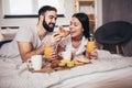 Happy couple having breakfast in bed Royalty Free Stock Photo