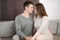 Romantic happy couple man and woman sitting at home on cozy sofa, hugging, showing caring affection, enjoying a Royalty Free Stock Photo