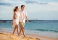 Romantic happy couple walking on beach at sunset Royalty Free Stock Photo