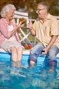 Romantic senior man and woman enjoy on summer holiday near swimming pool and  eating watermelon Royalty Free Stock Photo