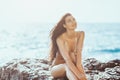 Portrait of beautiful young woman on wild rocky beach. Royalty Free Stock Photo