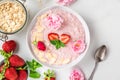 Romantic healthy breakfast. overnight strawberry oats with fresh berries, almonds and mint in a bowl with rose flowers