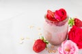 Romantic healthy breakfast. overnight strawberry oats with fresh berries and mint with rose flowers in a glass