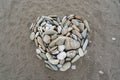 Romantic heart shape made from pebbles on a sandy beach top view. Abstract romance, valentine made of stones on black Royalty Free Stock Photo