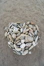 Romantic heart shape made from pebbles on a sandy beach, top view. Romance, valentine made from stones on black sand Royalty Free Stock Photo