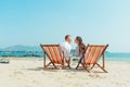 Romantic holiday travel. Portrait of happy young couple hugging near with deck chairs in luxury beach Royalty Free Stock Photo