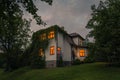 Romantic house with a light in the window. Night landscape in summer