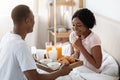 Romantic husband bringing breakfast in bed for his woman Royalty Free Stock Photo