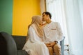 romantic husband kisses wife& x27;s forehead while sitting during Eid celebration