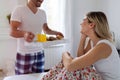 Romantic husband waking wife with breakfast in bed Royalty Free Stock Photo