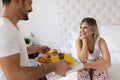 Romantic husband waking wife with breakfast in bed Royalty Free Stock Photo