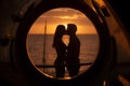 Romantic kiss of a couple in love at sunset, view through the porthole of the yacht.