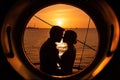 Romantic kiss of a couple in love at sunset, view through the porthole of the yacht.