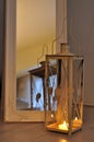 Romantic lantern reflection. Decorative mirror frame. Relaxing candlelight flame. Peaceful home interior