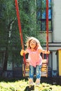 Romantic little girl on the swing, sweet dreams. childhood daydream. freedom. Playground in park. Small kid playing in